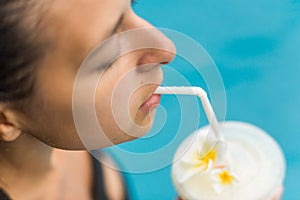 Woman drink fuit shake in pool