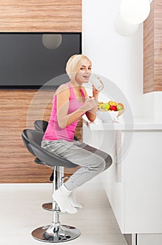 Woman drink orange juice glass in her kitchen