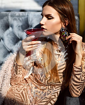 Woman drink red martini cosmopolitan cocktail sitting in restaurant cafe