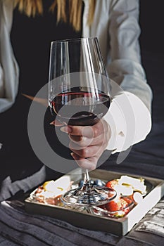 Woman drink red wine from transparent glass.