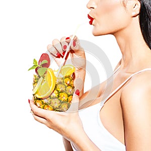 Woman drink tropical cocktail in pineapple with straw closeup