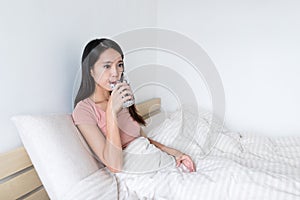 Woman drink of water on bed