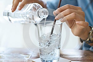 Woman drink water with ice in glass on a table in restaurant