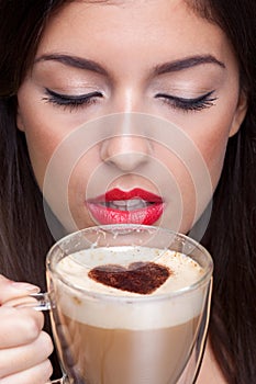 Woman drinking cappuccino coffee with love heart s