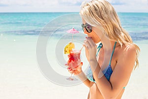Woman drinking cocktail on the beach