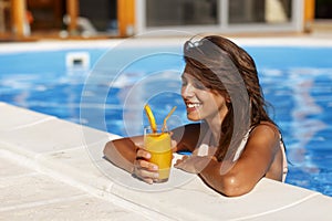 Woman drinking cocktail and relaxing in the swimming pool