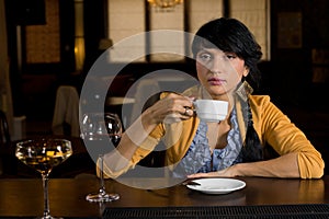 Woman drinking coffee at a bar counter