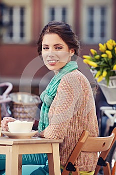 Una mujer bebiendo café en cafetería 