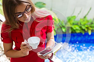 Woman drinking coffee checking Mails on phone