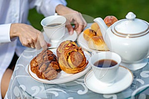 Woman drinking coffee with croissants