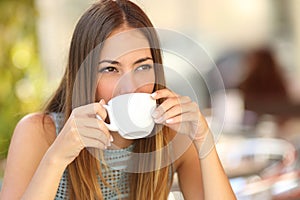 Una mujer bebiendo café taza en un restaurante terraza 