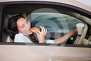 Woman drinking coffee and eating donnut on phone photo