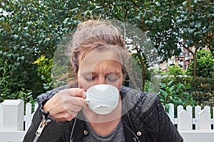 Woman drinking coffee in a garden