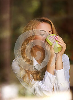 Woman drinking coffee indoors, enjoying the aroma of beverage