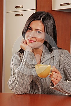 Woman drinking coffee in the kitchen.