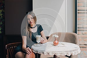 Woman drinking coffee in the morning at restaurant soft focus. Smiling pretty girl with cup of cappuccino. lady enjoy