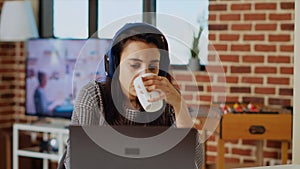 Woman drinking coffee in the morning and watching TV show at home
