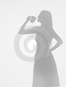 Woman drinking coffee from a mug, silhouette