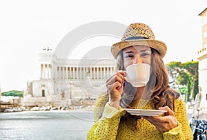 Woman drinking coffee on piazza venezia in rome