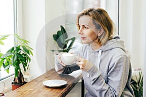 A woman is drinking coffee with pleasure