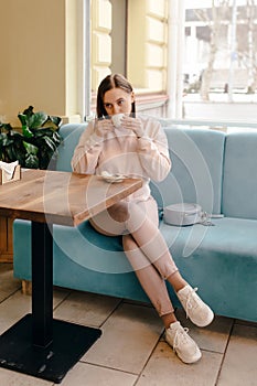 Woman drinking coffee while sitting on a cafe terrace