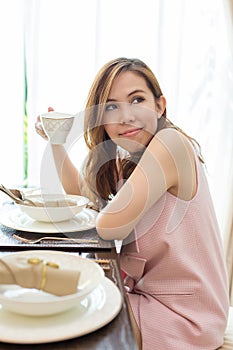 Woman drinking coffee at the table