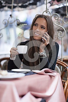 Woman drinking coffee and talking on the phone