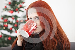 Woman is drinking coffee or tea on christmas