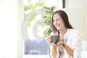 Woman drinking coffee or tea at home