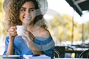 Woman drinking a cup of coffee at a coffee shop.
