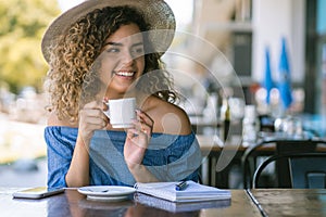 Woman drinking a cup of coffee at a coffee shop.