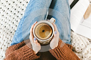 Woman drinking a cup of warm herbal orange tea