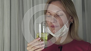 Woman drinking effervescent antipyretics pill dissolved in glass of water. Health care slow motion stock footage video