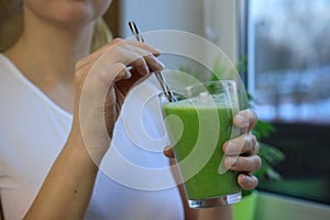 Woman drinking fresh raw green detox vegetable juice. Healthy lifestyle.