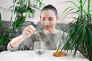 Woman drinking glass with Chlorophyll water, antioxidant beverage. Healthy lifestyle