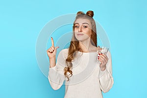 woman with drinking glass of water pointing up