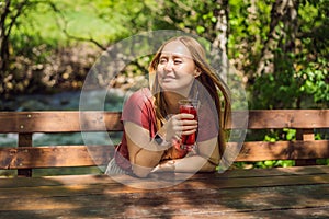 Woman drinking healthy fruits and vegetables juice smoothie in summer. Happy girl enjoying organic drink Portrait of a