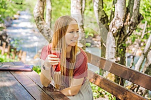 Woman drinking healthy fruits and vegetables juice smoothie in summer. Happy girl enjoying organic drink Portrait of a