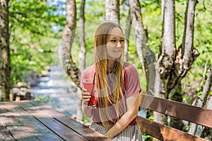 Woman drinking healthy fruits and vegetables juice smoothie in summer. Happy girl enjoying organic drink Portrait of a