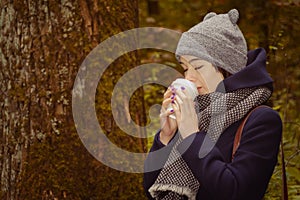 woman drinking hot coffee in the park