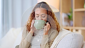 Woman drinking a hot cup of tea or coffee at home. Carefree, relaxed and cheerful young female smelling the aroma of a