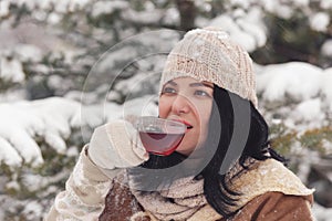 Woman drinking hot tea in the winter landscape