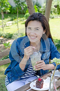 Woman drinking ice greentea and cake