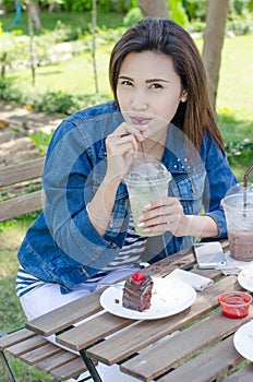 Woman drinking ice greentea and cake