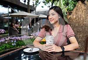 Woman drinking iced milk frappe in a cafe photo