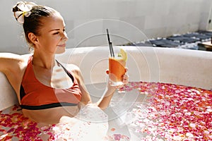 Woman Drinking Juice Cocktail, Relaxing Spa Flower Bath. Summer