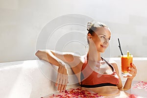 Woman Drinking Juice Cocktail, Relaxing Spa Flower Bath. Summer