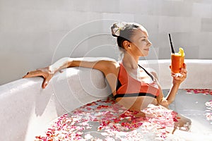 Woman Drinking Juice Cocktail, Relaxing Spa Flower Bath. Summer