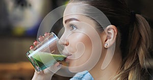 Woman drinking matcha latte in cafe