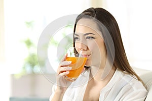 Woman drinking orange juice in a glass